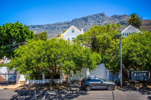 a car parked in a parking lot in front of houses at Cape Riviera Guesthouse in Cape Town
