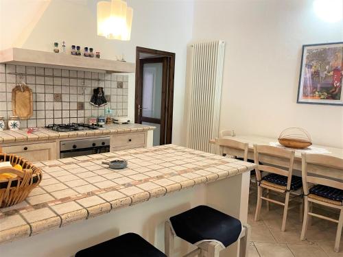 a kitchen with a counter and a table with chairs at Casa I 10 Puleri - Ampio e fresco terrazzo panoramico in Leni