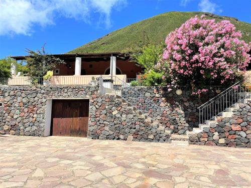 a stone wall with a building with a grass roof at Casa I 10 Puleri - Ampio e fresco terrazzo panoramico in Leni