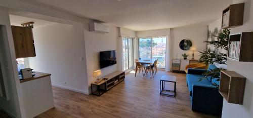 a living room with a blue couch and a table at Appartement avec 5 balcons et parking au cœur de la ville! in Arcachon