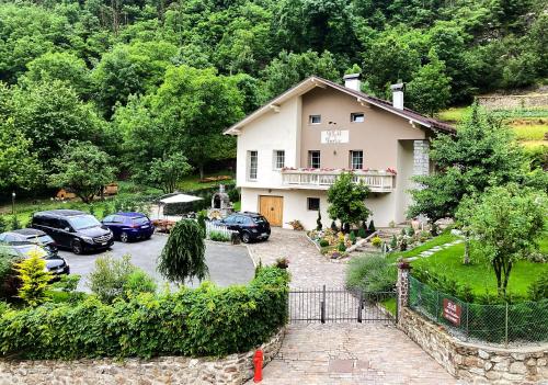 a house with cars parked in a parking lot at B&b Villa Paradiso in Mezzana