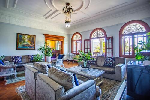 Cape Riviera Guesthouse في كيب تاون: غرفة معيشة كبيرة مع كنب وثريا