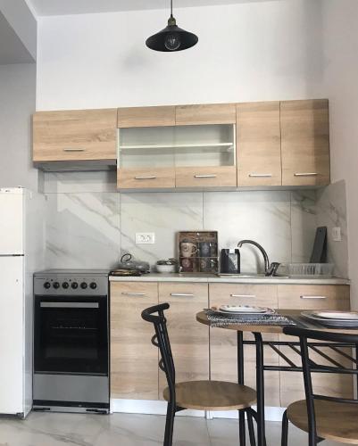 a kitchen with a stove and a table with chairs at Bafas Apartments in Plataria