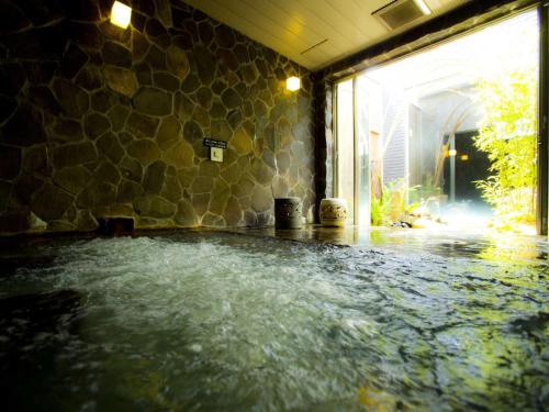 uma piscina de água no meio de um quarto em Kansai Airport Spa Hotel Garden Palace em Izumi-Sano