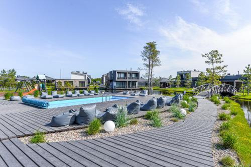 a swimming pool with chairs and a playground at Juros geismas in Palanga