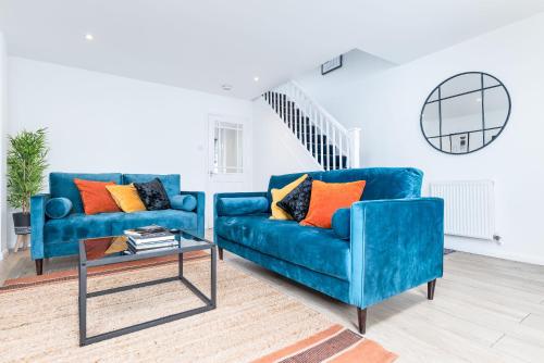 a living room with two blue couches and a table at Marham Close in Nottingham