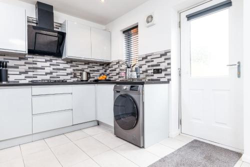 a white kitchen with a washing machine in it at Marham Close in Nottingham