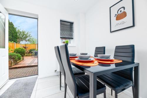 a dining room with a black table and chairs at Marham Close in Nottingham