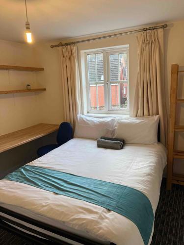 a bed with a bag sitting on top of it at Peaceful 3 BR Flat with A View Near Hospitals-Free Parking in Newcastle under Lyme