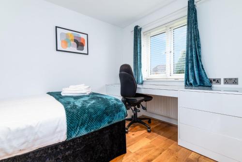 a bedroom with a bed and a desk and a chair at Marham Close in Nottingham