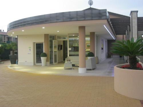 a house with a courtyard with chairs and a table at Residence La Margherita in Lazise