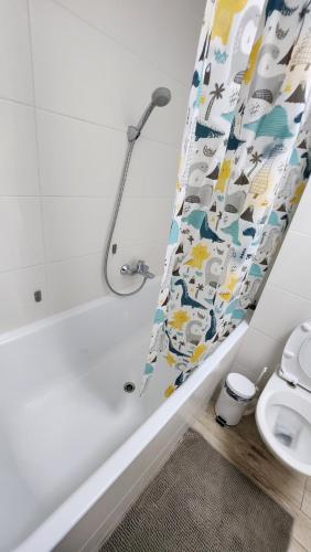 uma casa de banho com uma cortina de chuveiro e um WC em Luxury Appartement de 130 m2 avec 3 chambres em Ardon