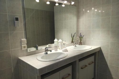 a bathroom with two sinks and a large mirror at Au bois dormant in Pont-du-Casse