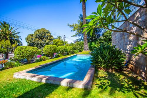 a swimming pool in the yard of a house at Cape Riviera Guesthouse in Cape Town