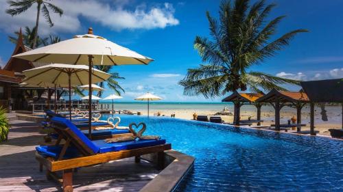 una piscina del complejo con sillas y sombrillas y la playa en Sasitara Thai Villas en Choeng Mon Beach