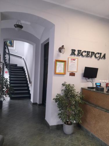 a lobby with stairs and a sign on the wall at Hotelik w Centrum in Toruń