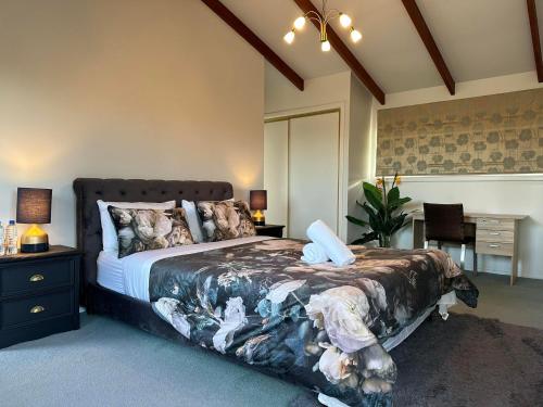 ein Schlafzimmer mit einem Bett und einem Schreibtisch sowie ein Esszimmer in der Unterkunft The Airport Homestay House in Christchurch