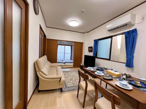 a living room with a dining room table and a living room at 千間川-緑橋 in Osaka