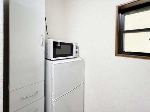 a microwave sitting on top of a refrigerator at 千間川-緑橋 in Osaka
