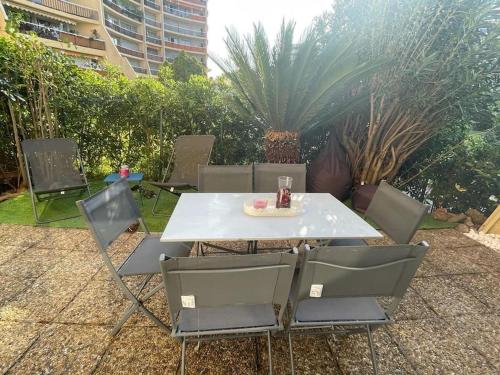 uma mesa branca e cadeiras com uma bebida em Magnifique 2p Cannes Marina em Mandelieu-la-Napoule