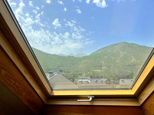 a window in a room with a view of mountains at Dúplex amb encant al casc antic d'Esterri i vistes úniques by RURAL D'ÀNEU in Esterri d'Àneu