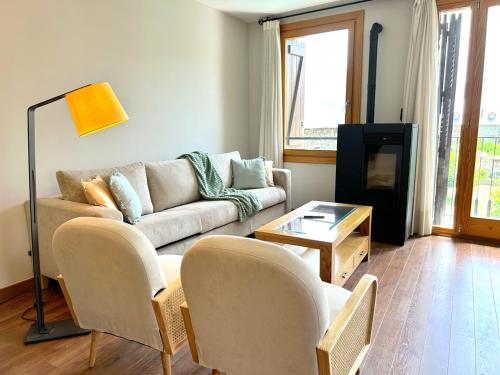 a living room with a couch and a tv at Dúplex amb encant al casc antic d'Esterri i vistes úniques by RURAL D'ÀNEU in Esterri d'Àneu