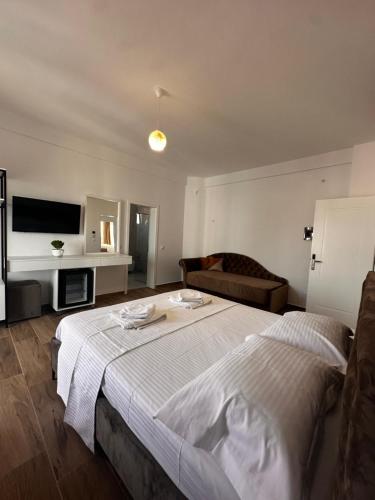 um quarto com uma cama grande e um sofá em Hotel Belle Vue em Ksamil
