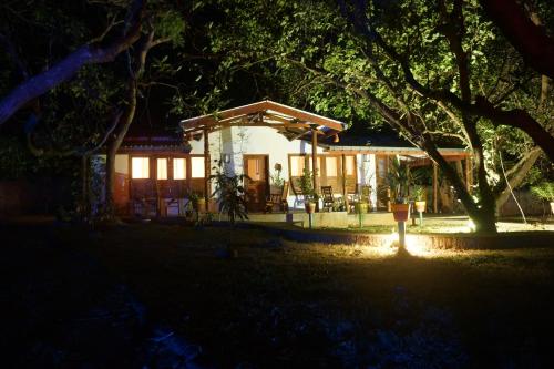 a house lit up at night with a tree at Flash Rock Villa in Sigiriya