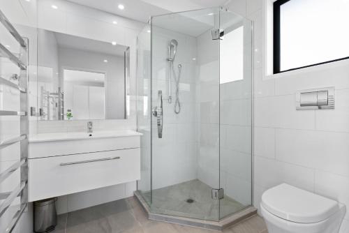a bathroom with a shower and a toilet and a sink at Vineyard Vacation in Mangawhai