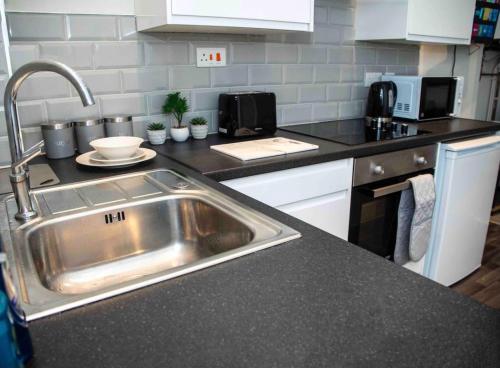 a kitchen with a sink and a counter top at Cosy Convenient 1 BR Flat at Central Stoke Near Hospitals and Univesities in Stoke on Trent