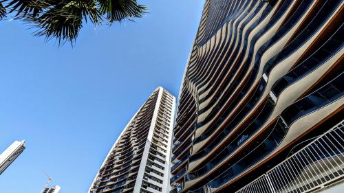 a tall building with a blue sky in the background at SUNSET WAVES sun & beach apartments in Benidorm