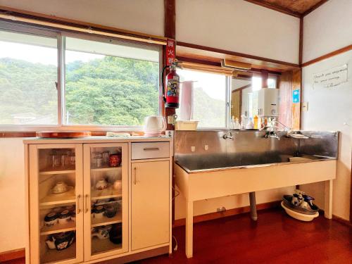 een keuken met een wastafel naast een raam bij Iriyama-So in Shimoda
