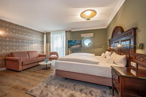 a hotel room with a bed and a couch at Strandhotel Heringsdorf in Heringsdorf