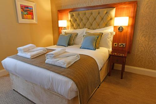 a hotel room with a large bed with towels on it at The Townhouse Aberfeldy - Rooms & Breakfast in Aberfeldy