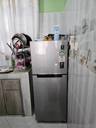 eine Küche mit einem Kühlschrank aus Edelstahl und einer Theke in der Unterkunft Ngomg in Nairobi