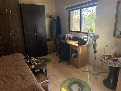 a room with a bed and a desk and a window at Oak Chalet شاليه الملول 