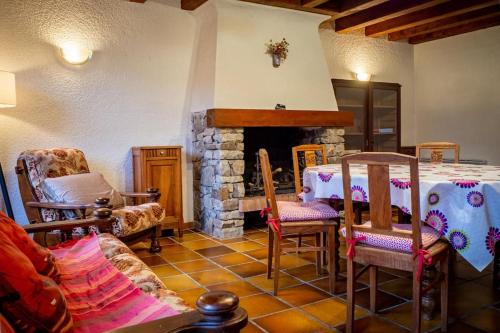 - un salon avec une table et une cheminée en pierre dans l'établissement Maison avec vue sur la montagne Les Circaètes, à Bourisp