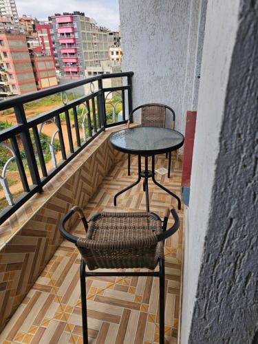 einen Tisch und einen Stuhl auf dem Balkon in der Unterkunft Ngomg in Nairobi