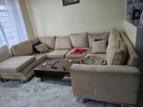 ein Wohnzimmer mit einem Sofa und einem Couchtisch in der Unterkunft Ngomg in Nairobi