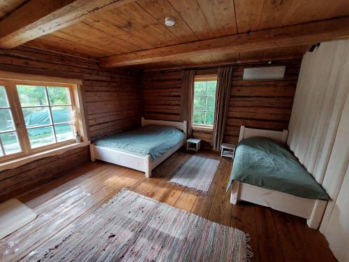 a room with two beds in a log cabin at Kossa Tarõ 