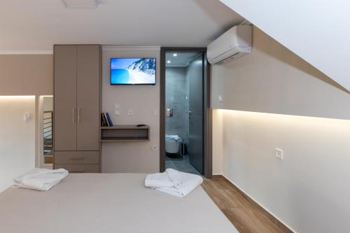 a bedroom with a bed and a tv on the wall at Elite City Apartments & Maisonettes in Lefkada