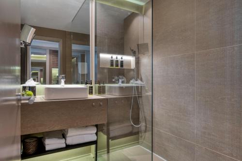 a bathroom with a shower with a sink and a mirror at Hotel America Barcelona in Barcelona