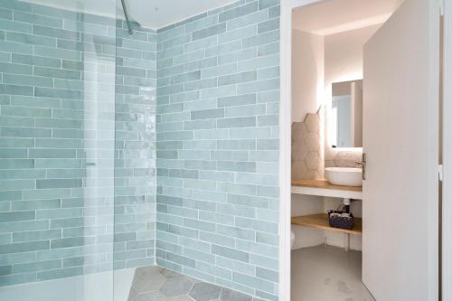 La salle de bains est pourvue d'une douche et de carrelage bleu. dans l'établissement Nocnoc Le Parasol, à Marseille