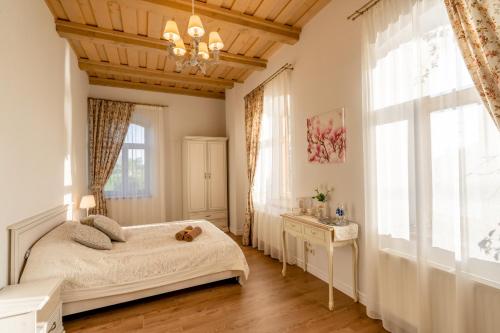 a bedroom with a bed and a large window at Dēseles dzirnavas - Guest House in Embūte