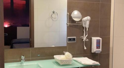 a bathroom with a sink and a mirror at Hotel-Asador Montes Oretanos in Pulgar