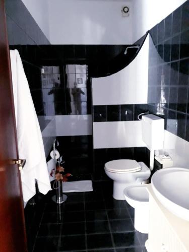 - une salle de bains en noir et blanc pourvue de toilettes et d'un lavabo dans l'établissement Casa vacanze zina, à Altavilla Milicia