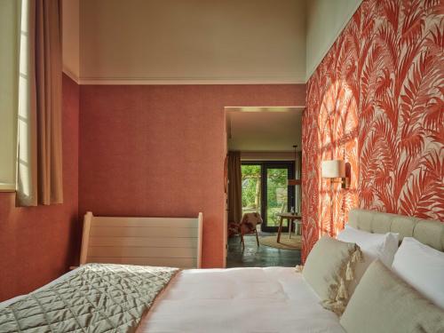 a bedroom with a bed and a red wall at Kerkhotel Bij De Pastorie in Reitsum