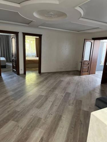 an empty room with wooden floors and a room with windows at ZAK Home in Gyumri