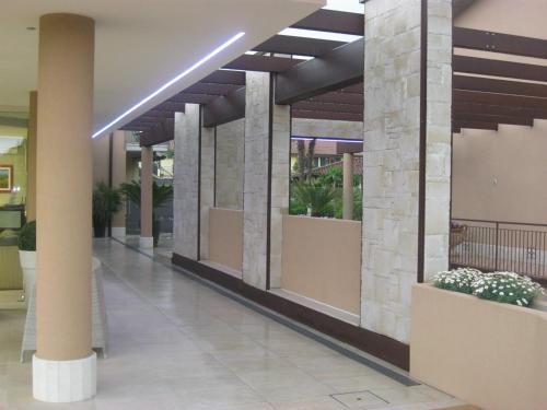a lobby of a building with pillars and potted plants at Residence La Margherita in Lazise