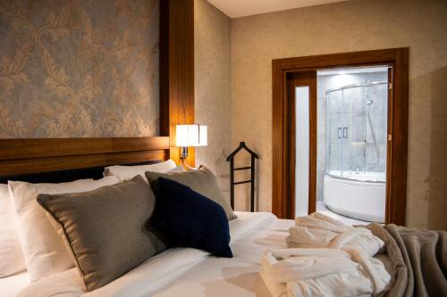 a bedroom with a bed with a bath tub and a window at Parwar Hotel in Duhok